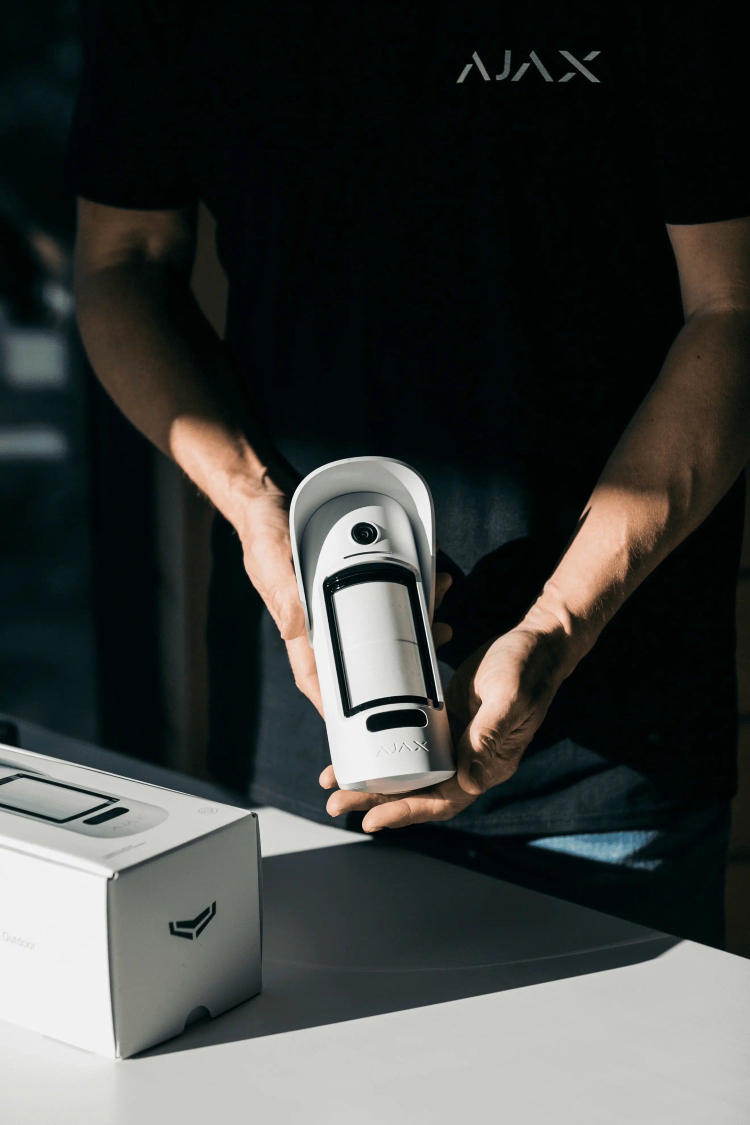 Un installatore ha in mano un dispositivo Ajax