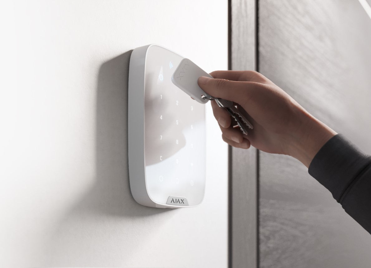 una mano passa il Tag Jeweller bianco su una tastiera, Ajax system su Easyalarm